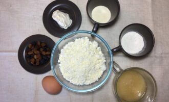 Шаг 1: Подготовьте ингредиенты: яйцо, мед, сметану, муку, творог, изюм и манную крупу.