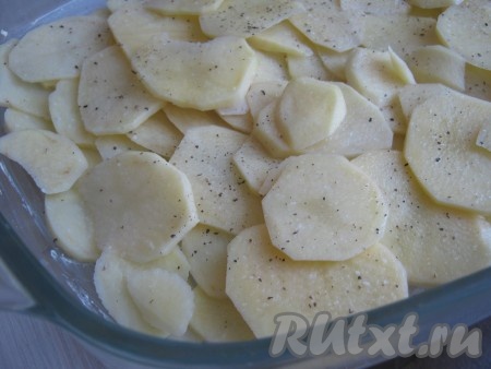 Форму смазываем маслом и выкладываем картофель равномерным слоем, солим и перчим.
